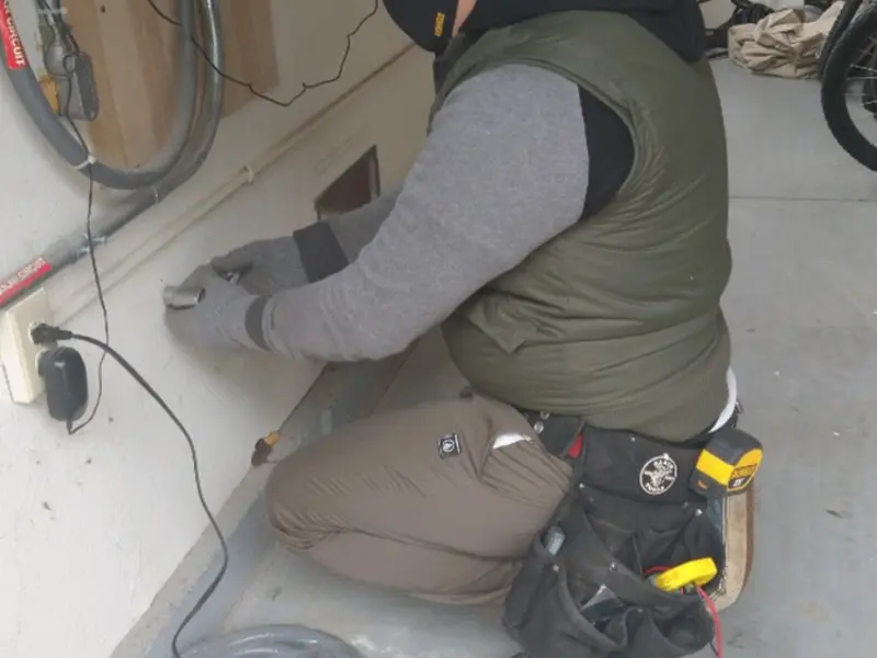Electrician performing outlet wiring in a St. Augusta garage
